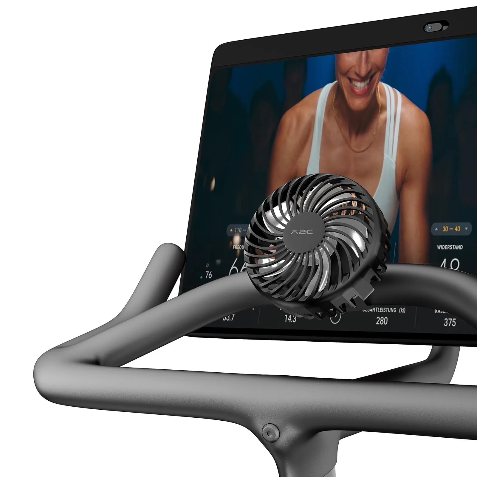 A2C fan clipped to the handlebar of an exercise bike in front of its screen